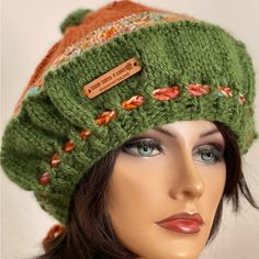 a close up of a mannequin head wearing a green hat with flowers on it