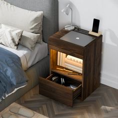 a bed room with a neatly made bed and a laptop on top of the night stand