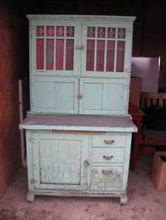 an old china cabinet with glass doors and drawers