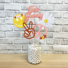 a glass jar filled with rocks and paper flowers