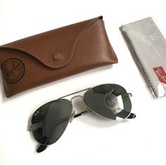 Authentic Ray Ban Aviator Sunglasses In Silver. These Have Been Worn, I Just Stuck The Sticker Back On Them. I Think G 15 Refers To Polarization But The Ray Ban Logo On The Glasses Does Not Have The Little P Beside It. Frames Are Silver With Black Ear Pieces. There Is Light Scratching Consistent With Wear, Please See Pics. Includes Unopened Cleaning Cloth And Ray Ban Case. Sunglasses Originally Purchased At T. J. Maxx. Sorry, No Trades. Ray Ban Logo, Ear Pieces, Sunglasses Silver, The Ray, Ray Ban Aviator, Ray Ban Aviators, Colored Sunglasses, Silver Frame, Aviator Sunglasses