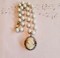 I love the simplicity of these natural Riverstone beads that I used to make the chain for this beautifully carved antique cameo.  The cameo is gold filled and marked "1-20d12K".  It measures 1-3/4" from top of cameo loop to the bottom.  Total length of necklace is 17" (can be lengthened if needed). I love working with antique and vintage parts and do my best to describe and show them in photo's. Please let me know if you have any questions. Thanks for visiting my shop! - Debbie Antique Oval Beaded Necklaces, Cream Beaded Chain Jewelry Gift, Antique Beaded Chain Jewelry Gift, Antique Beaded Chain Jewelry As Gift, Antique Jewelry With Beaded Chain For Gifts, Vintage Jewelry With Oval Gemstone Beads, Antique Single Strand Beaded Necklace Gift, Antique Single Strand Beaded Necklace As Gift, Gold Carved Round Beads Jewelry