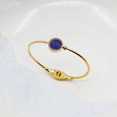 Lapis Lazuli d'Afghanistan, pierre précieuse de la royauté &, de la spiritualité, favorisant calme et communication
Pierre brute semi-précieuse sélectionnée de manière éthique, taillée et polie à la main avec savoir-faire
Monture unique en verre protégeant la pierre contre les chocs, chutes, coups, rayures, l'eau, et la chaleur
Délicat zircon minutieusement serti sur la sphère élégante du bracelet
Bracelet en acier inoxydable 316
Bracelet plaqué sur de l'acier inoxydable 316

TAILLE DU BRACELET Spiritual Blue Tarnish Resistant Jewelry, Luxury Healing Round Jewelry, Blue Fine Jewelry Bangle For Gifts, Blue Gold Bracelet With 17 Jewels For Gift, Luxury Gold Gemstone Bracelet As A Gift, Luxury Gold Gemstone Bracelet Gift, Luxury Gemstone Bangle Gift, Elegant Bangle Jewelry For Healing, Elegant Bangle For Healing