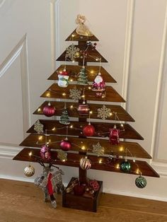 a wooden christmas tree with ornaments on it