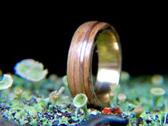 a wedding ring sitting on top of green moss