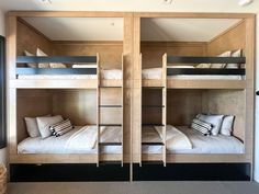 two bunk beds with white sheets and pillows in a room that has carpeted flooring