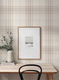 a wooden table with a plant on it next to a wallpapered wall in a room