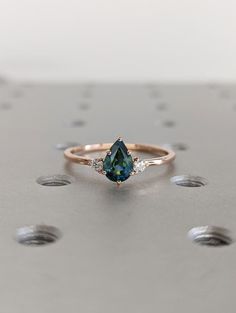 One of a Kind Montana Sapphire Ring, Pear Teal Sapphire Diamond/Moissanite Trellis Ring, Vintage Inspired Peacock Sapphire Engagement Ring * Images show 14K Rose Gold option. * Kindly be aware that the inherent uniqueness of peacock sapphires means that individual stones may exhibit subtle variations in color. Our photos aim to capture the essence of each distinct stone, but please understand that the natural beauty of these gems results in slight differences in hues from one piece to another. D Sapphire Ring Pear, Teardrop Sapphire Ring, Nontraditional Wedding Rings, Peacock Sapphire Engagement Ring, Sapphire Engagement Ring Gold, Pear Sapphire Ring, Ring Images, Trellis Ring, Peacock Sapphire