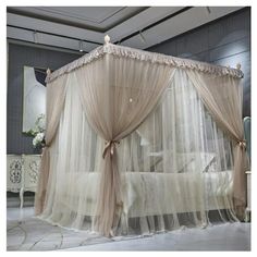 a canopy bed with sheer curtains and lace on the top, in a bedroom setting