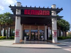 the front entrance to a restaurant with palm trees