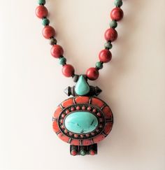 Estate Vintage designed from pendant.  The necklace weighs 4.4 ounces and 17 inches with the pendant. The beads are red clay and turquoise.  The pendant is coral, turquoise and silver. The pendant opens from the back to stash treasures, charms or photographic memories. Artisan Red Necklace With Round Pendant, Red Medallion Necklace With Large Pendant, Artisan Red Jewelry With Large Pendant, Traditional Turquoise Pendant Necklace With Gemstone Beads, Hand-strung Turquoise Pendant Necklace, Artisan Red Round Pendant Jewelry, Traditional Red Medallion Necklace, Turquoise Amulet Necklace With Gemstone Beads, Artisan Red Coral Jewelry For Gifts