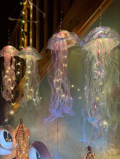 some lights that are hanging from strings in the air with jellyfishs on them