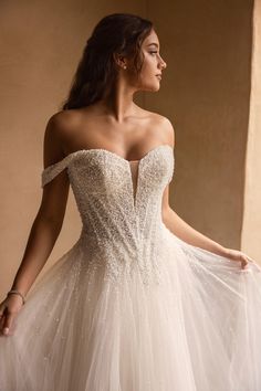 a woman in a wedding dress is posing for the camera with her hand on her hip