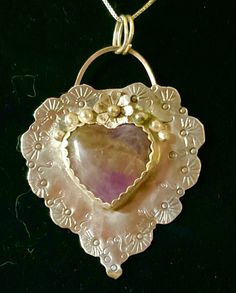 "Remember your love with this charming, sentimental gift of sterling silver.  Completely hand fabricated and stamped, this delightful piece also features a genuine purple agate stone and a sterling blossom with dewdrops. Measures 1 3/4 x 1 3/4 inches. 18\" sterling chain included." Heart-shaped Agate Jewelry For Healing, Heart-shaped Agate Healing Jewelry, Artisan Heart Pendant Jewelry, Healing Heart-shaped Agate Jewelry, Heart-shaped Agate Jewelry With Natural Stones, Heart Shaped Agate Jewelry With Natural Stones, Amethyst Heart Pendant Jewelry For Anniversary, Bohemian Sterling Silver Jewelry For Mother's Day, One Of A Kind Silver Amethyst Jewelry