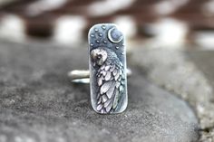 This listing is for one striking and unique sterling silver barn owl and moon ring. It features a detailed and dimensional barn owl under a crescent moon with stars. This thick and sturdy owl focal is fired onto 9 gauge half round wire. This ring is perfect for any owl and nature lover! It looks great solo or stacked with other rings and bands. - Choose your size at check-out! - Owl focal measures 28 mm by 12mm. - Ring band is 2mm wide by 1.5mm thick. - Made to order just for you! Please take note of estimated delivery times in the shipping section at checkout! Want to stack it with some awesome textured silver stacking bands? Find them here: https://www.etsy.com/listing/532906393/silver-stacking-rings-simple-silver-ring?ref=shop_home_active_16 Not sure of your ring size? Purchase one of t Barn Owl Ring, Witch Ring, Witch Rings, Ring Moon, Owl Ring, Silver Rings Simple, Witch Jewelry, Owl Jewelry, Moon Ring