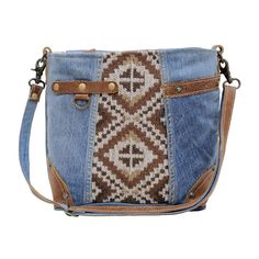 a cross body bag made out of denim and leather with an embroidered design on the front