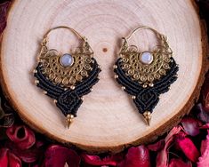 These stunning macramé earrings feature a beautiful combination of moonstone and gold brass details, handcrafted with precision and care using the ancient art of macramé. The elegant black threadwork contrasts with the warm brass accents, creating a unique and powerful design that draws inspiration from ethnic and bohemian jewelry styles. These statement hoops are perfect for women seeking a bold, spiritual, and empowered look, whether for daily wear or special occasions. Each piece is handmade Traditional Macrame Jewelry For Festivals, Traditional Macrame Earrings, Black Crystal Earrings, Spiritual Balance, Feel Empowered, Big Jewelry, Brass Beads, Earrings Hoops, Jewelry Styles