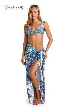 This pareo by Sunshine 79 features an elegant white and blue multicolored paisley print, exuding a blend of sophistication and playfulness. Its intricate pattern adds a touch of bohemian charm to your poolside style. This gorgeous pareo looks equally beautiful with a one-piece suit as it does a bikini top and bottoms. The sarong-style fit that ties at the side lends a chic silhouette. [split] Details Pareo cover up Adjustable side tie with tassels One size fits all Fabric 100% Rayon Crepe White Floral Print Swimwear For Beach Cover-up, Bohemian Tropical Print Sarong For Pool, Bohemian Sarong With Tropical Print For Pool, White Floral Print Sarong For Beach Season, White Floral Print Beachwear Sarong, Bohemian Printed Sarong For Pool, White Bohemian Sarong For Spring, Bohemian White Sarong For Spring, Spring Bohemian White Sarong