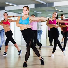 a group of people in a dance class doing different poses and stretching their arms with each other