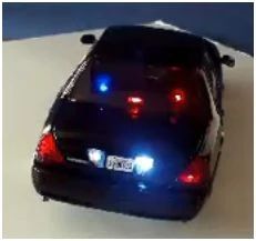 a police car with its lights on is shown in this image, it appears to be blue