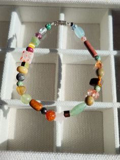 a bracelet with multicolored beads in a white box