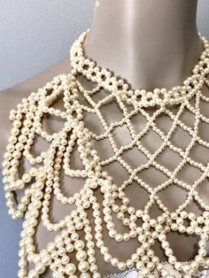 "Pretty faux pearl necklace with all over beads to dress up any look. Beads create a cross cross and drape loop design down the front. Adjustable clasp and chain in gold toned and variety of size beads Measurements: Bib front is 10\" long by 10\" to 5\" wide from top to bottom" Elegant Gold Beaded Necklaces For Evening, Elegant Pearl Beaded Necklace With Gold Beads, Gold Beaded Pearl Necklace For Evening, Pearl White Beaded Jewelry, Elegant Beaded Pearl Choker Necklace, Elegant Pearl Choker Necklace With Beaded Chain, Elegant Beaded Chain Choker For Weddings, Elegant Wedding Choker With Beaded Chain, Elegant Beige Choker Necklace