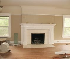 an empty living room with a fireplace and hard wood flooring in the foreground