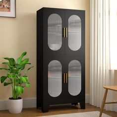 a tall black cabinet with glass doors next to a potted plant in a living room