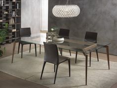 a glass dining table with chairs around it