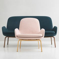 two chairs sitting next to each other in front of a white wall and one has a pink chair on it