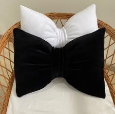 a black and white bow tie pillow on a wicker chair