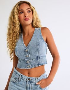 Levi's Premium Mona Denim Corset. What's Better Than A Flattering Corset? Our Mona Denim Corset. We Designed It With A Slim Fit And A Button-Up Front. V-Neck. Sleeveless. Cropped Length. Adjustable Buckle And Strap At Back. 100% Cotton. Machine Wash. Imported. Model Is Wearing A Size Small. Model Measurements:height: 5'8" Bust: 32"waist: 25"hips: 36" Light Wash Denim Vest With Button Closure, Sleeveless Denim Blue Corset For Summer, Denim Top With Button Closure, Fitted V-neck Top In Medium Wash, Casual Denim Sleeveless Corset, Medium Wash Fitted V-neck Top, Fitted Medium Wash V-neck Tops, Summer Denim Corset With Corset Back, Casual Sleeveless Denim Blue Corset