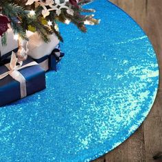 a blue table with presents on it and a christmas tree