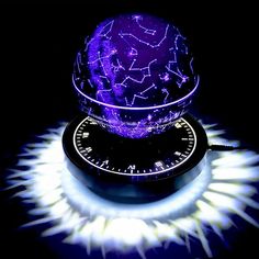 a purple ball with stars on it sitting on top of a clock