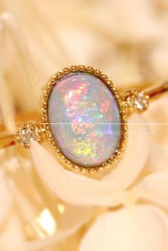 This stunning shimmery stone is opal. This opal ring can go with every outfit #opalring #gemstonering #engagementring #goldring Gold Opal Ring With Spiritual Style, Heirloom Gold Opal Gemstone Ring, Heirloom Opal Rings In Gold, Heirloom Gold Opal Promise Ring, Gold Opal Ring With Halo Design - Gift, Gold Opal Ring Fine Jewelry, Gold Opal Wedding Jewelry, Spiritual Yellow Gold Oval Opal Ring, Gold Gemstone Rings For Marriage