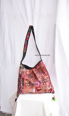 Welcome to HarmonyHandicraftCo Vintage banjara hand embroidery shoulder bag is large enough to hold everything you need throughout your day, Made of antique hand-embroidery. Thread textiles, with intricate embellishments, bag is truly unique. Size in Inches ( Approx ) Height with handle  31 Inches Bag Height - 14 Inches Width - 19 Inside Pocket - 1 Outside Pocket - No Very colorful and striking color purse, It can be a unique gift for girls, girl friends, sisters, daughters. Housewives, and can a perfect match with any of dress code. Note:- You can hand wash in cold water and hang to dry or use wet wipes to clean them. Banjara tote bag, Afghani tote  bag, Afghani bag, Banjara shoulder bag, embroidery bag, Tote bag, Handmade bag, Boho bag, Vintage Indian handmade bag, Banjara bag, Large bag Traditional Bucket Shoulder Bag For Festival, Traditional Shoulder Bucket Bag For Market, Traditional Hobo Bag With Adjustable Strap For Daily Use, Embroidered Rectangular Shoulder Bag For Festivals, Rectangular Embroidered Shoulder Bag For Festivals, Bohemian Shoulder Bag With Woven Motifs, Bohemian Handheld Bag For Market, Handmade Tote Shoulder Bag For Festivals, Handmade Multicolor Embroidered Tote Shoulder Bag