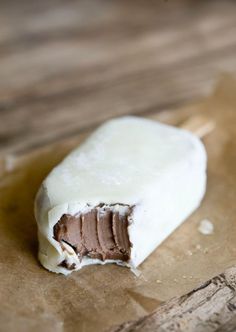 a piece of food sitting on top of a brown paper covered in white frosting