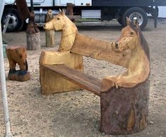 there is a statue of two horses sitting on a bench in the middle of a parking lot