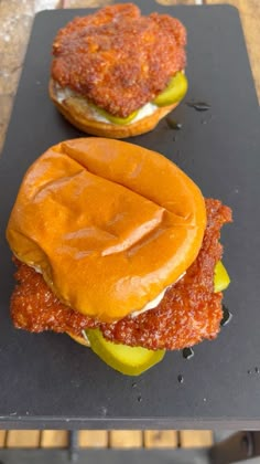 two burgers sitting on top of a black tray