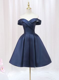 Honor your sophisticated style with this exquisite navy blue homecoming dress. The off-the-shoulder neckline creates a chic and timeless look, perfectly framing your shoulders and collarbone. The bodice is adorned with a unique wrap design that cinches at the waist, providing a flattering and comfortable fit. The full, pleated skirt adds a touch of vintage elegance, allowing for beautiful movement as you dance or walk. The rich navy satin fabric gives the dress a luxurious feel and a subtle sheen, ensuring you stand out in any crowd. This dress combines elegance and comfort, making it perfect for a night of celebration. Ideal for those who appreciate classic beauty with a modern twist, this homecoming dress will make you feel like royalty. Make a lasting impression with this stunning piece Navy Dama Dresses, Navy Blue Dama Dresses, Elegant Off-shoulder Strapless Dress For Homecoming, Elegant Off Shoulder Dress For Homecoming And Prom, Elegant Off-shoulder Dress For Prom And Homecoming, Elegant Blue Knee-length Off Shoulder Dress, Elegant Blue Off Shoulder Dress For Prom Season, Quinceanera Dama Dresses, Short Puffy Dresses