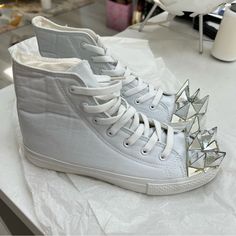 Brand: Prospekt Hand-Crafted In Hong Kong White Canvas High Top Sneakers (Like Hi-Top Chucks) With White Laces And Decorative Mirrored Spikes On The Toes. Very Unique. Purchased From Solestruck In 2015. New, In Box, And Never Used. Size 39 White Sporty High-top Sneakers For Summer, Sporty White High-top Sneakers For Summer, Low-top Skate Shoes For Summer Streetwear, Low-top Skate Shoes For Streetwear In Summer, Summer Low-top Skate Shoes For Streetwear, Spring Flat High-top Sneakers For Streetwear, Lace-up Canvas Shoes With Studded Rubber Outsoles For Streetwear, White Sneakers With Studded Rubber Outsoles For Summer, White Sneakers With Studded Outsoles For Summer