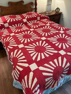 a bed with a red and white quilt on it