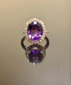 DeKara Designs Collection Metal- 18K Yellow Gold, .750. Stones- 1 Oval Genuine Amethyst 11.5 MM x 9.00 MM, 44 Round Diamonds F-G Color VS1-VS2 Clarity, 0.46 Carats. Latest of my creations! A Beautiful Amethyst Diamond Halo Engagement Ring Made in 18K Yellow Gold. There is a beautiful genuine purple Amethyst in the center of the ring that is professionally set in between four double prongs. The Amethyst is a beautiful and rich in color and goes extremely well with the yellow gold. Amethyst is sur Luxury 14k Gold Purple Rings, Luxury Purple Gemstones With Halo Setting, Luxury Purple 14k Gold Rings, Exquisite Amethyst Rings With Gemstone Accents, Luxury Purple Jewelry For Wedding, Exquisite Yellow Gold Amethyst Ring With Accent Stones, Luxury Purple Amethyst Ring With Halo Setting, Gold Amethyst Diamond Ring For Wedding, Yellow Gold Amethyst Wedding Ring