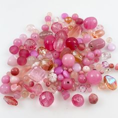 a pile of pink beads sitting on top of a white table