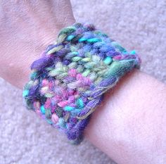 a close up of a person's arm wearing a knitted bracelet