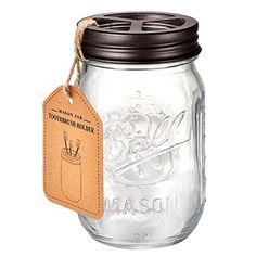 a mason jar with a leather tag hanging from it's front and side, on a white background