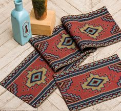 three placemats on the floor next to a blue vase