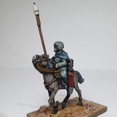 a toy soldier riding on the back of a horse with a spear in his hand