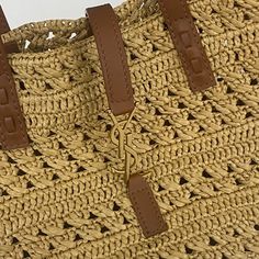 a close up of a straw bag on a white background with brown handles and straps