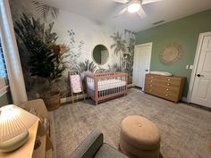 a baby's room with green walls and palm trees